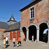 Toeristen bezoeken de kasteelhoeve van Falaën in de Ardennen, België

